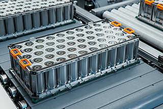 Ausschnitt aus der Batteriemodulproduktion: Fließband mit Batteriepacks, die transportiert werden.