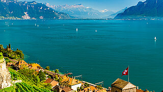 Schweizer See mit Bergenlandschaft im Hintergrund.