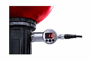 P0-Wächter mit leuchtender Anzeige „bar 110“ angebracht an einen Hydraulikspeicher